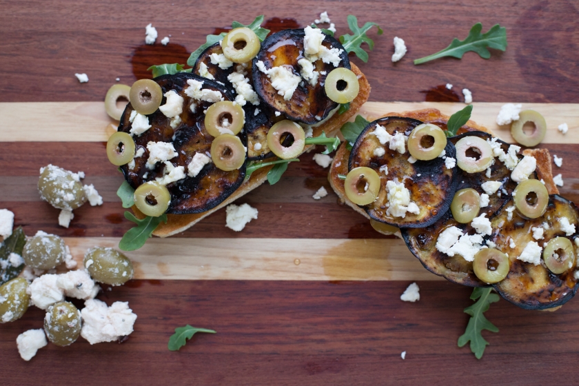 GRILLED EGGPLANT TARTINES WITH ARUGULA, FETA, GREEN OLIVES AND HONEY